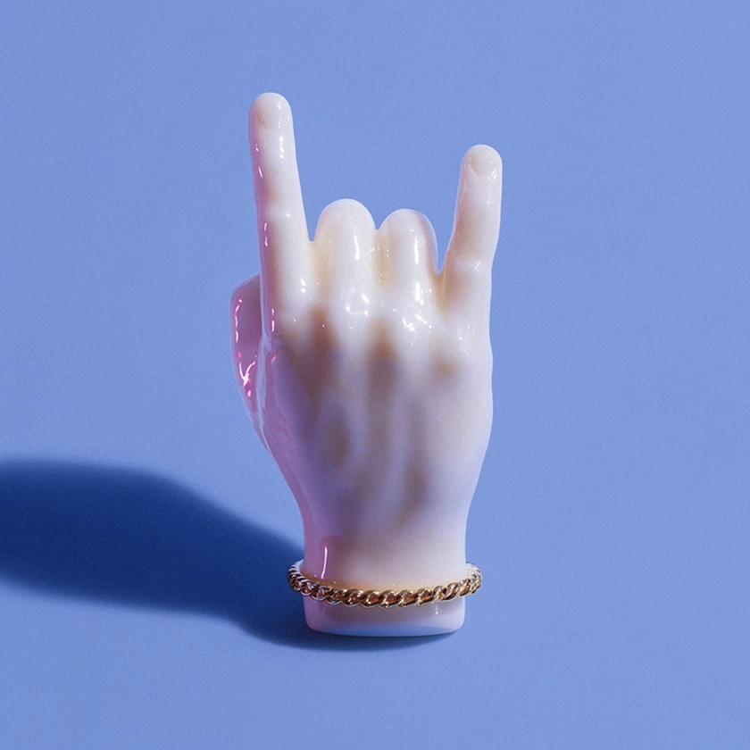 A white hand with a gold bracelet and a peace sign.