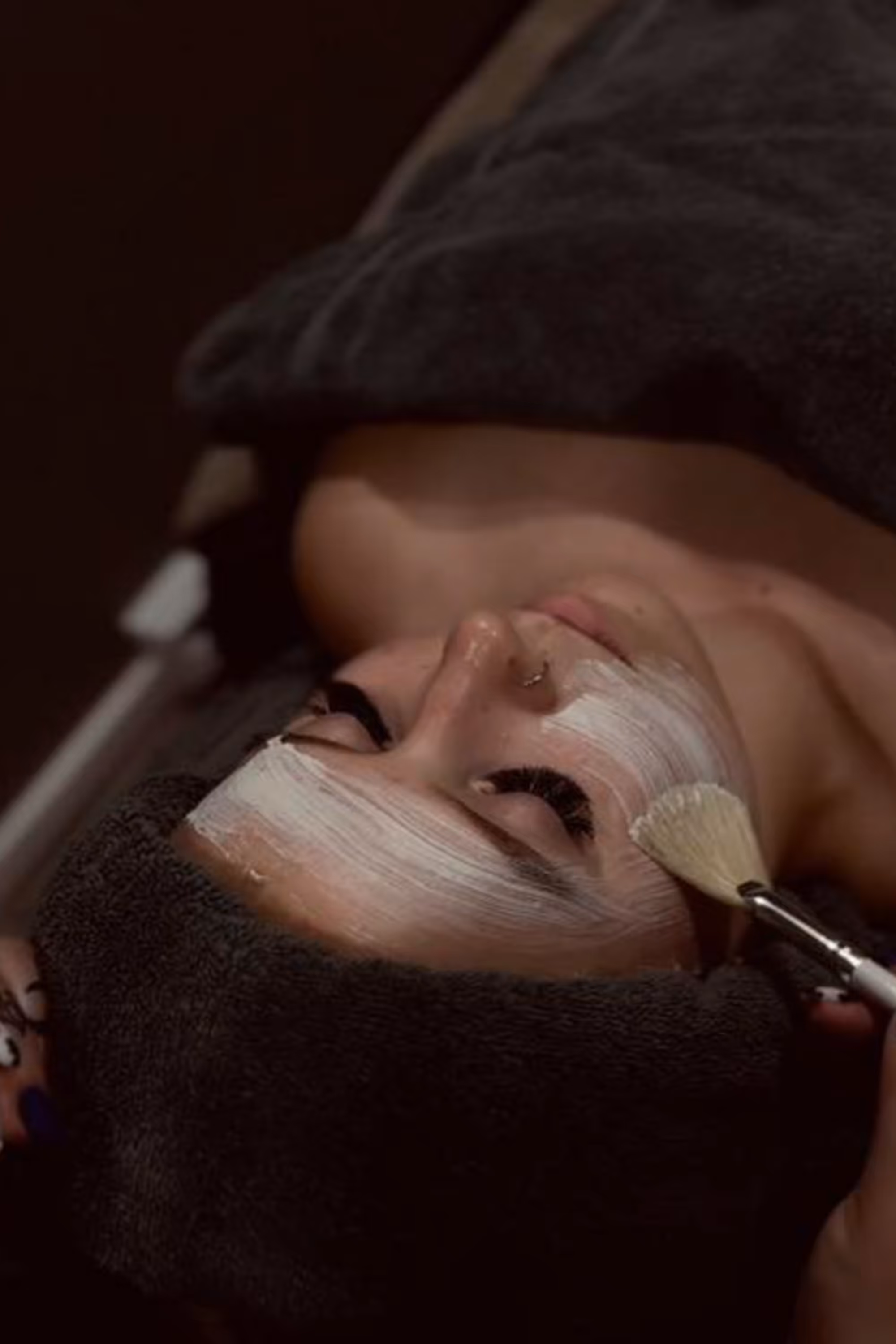 Asiakas nauttii rentouttavasta kasvohoidosta