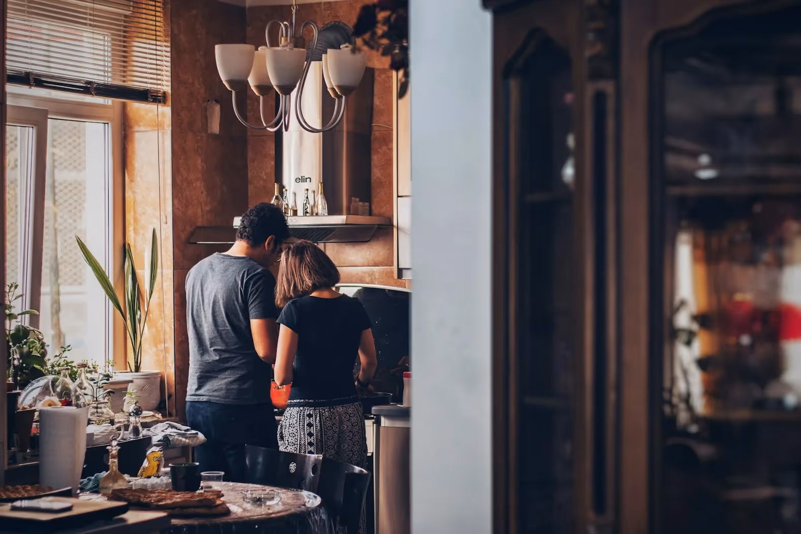A couple makes something on their kitchen.