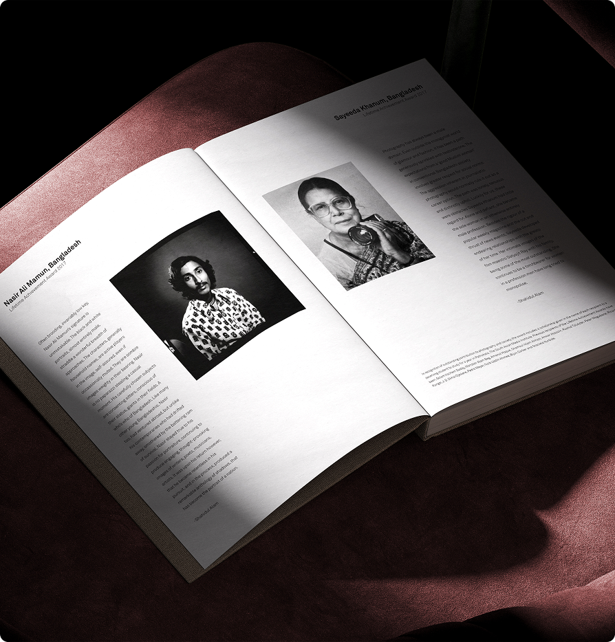 Open book showing black-and-white portraits and biographical text of Nasir Ali Mamun and Sayeeda Khanum, both from Bangladesh.