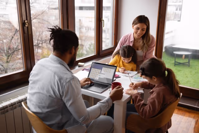 Family with young child sitting together at a table