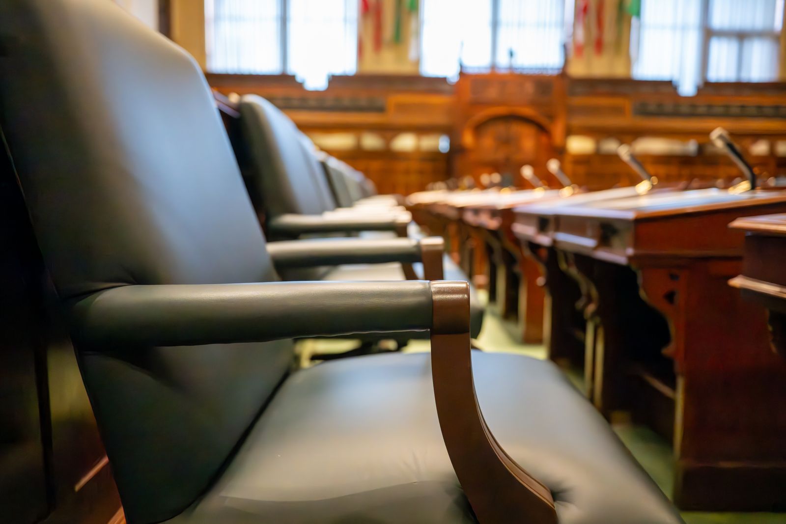 Empty rows of seats in a wood-panelled courtroom