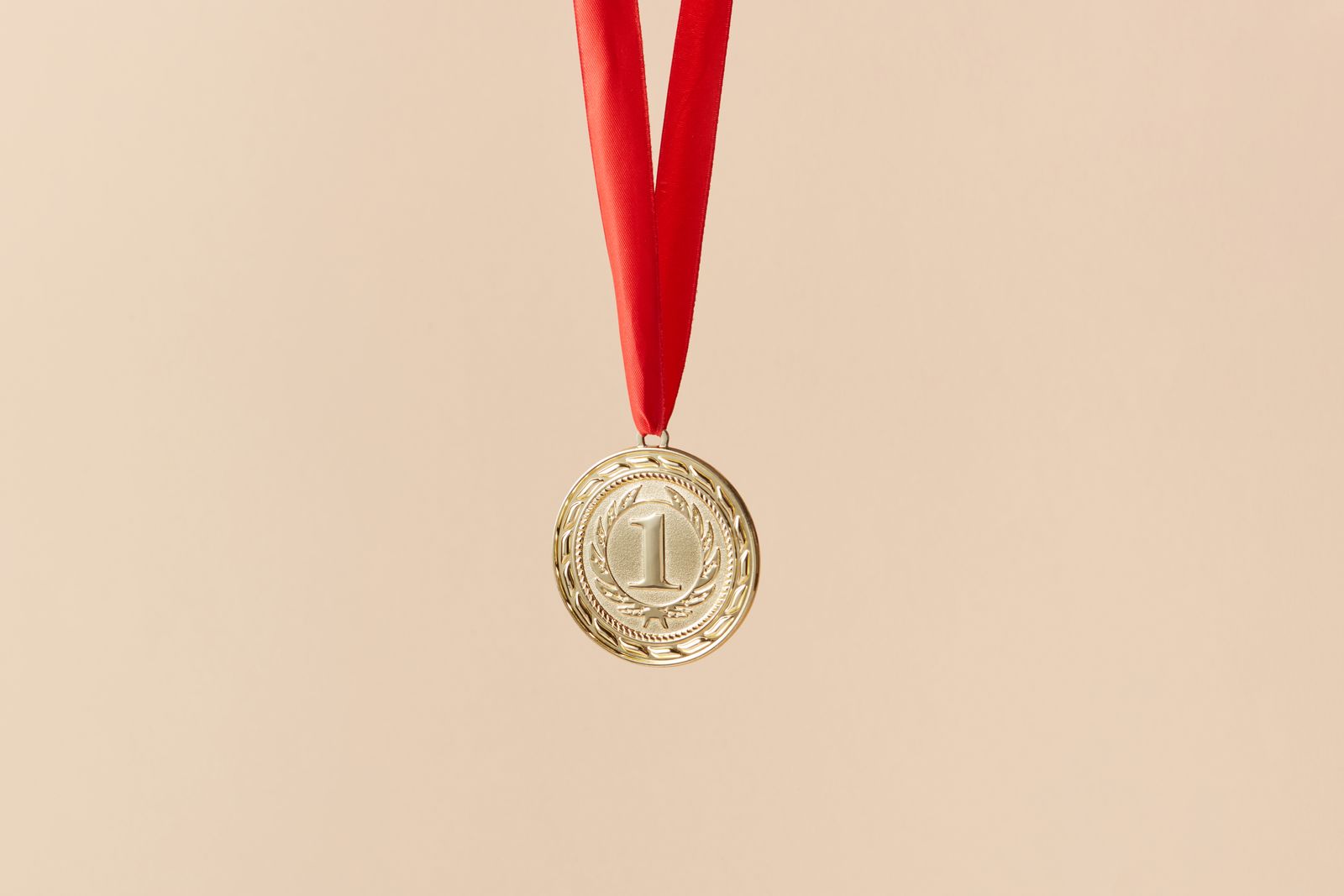 A gold medal hanging on a red ribbon