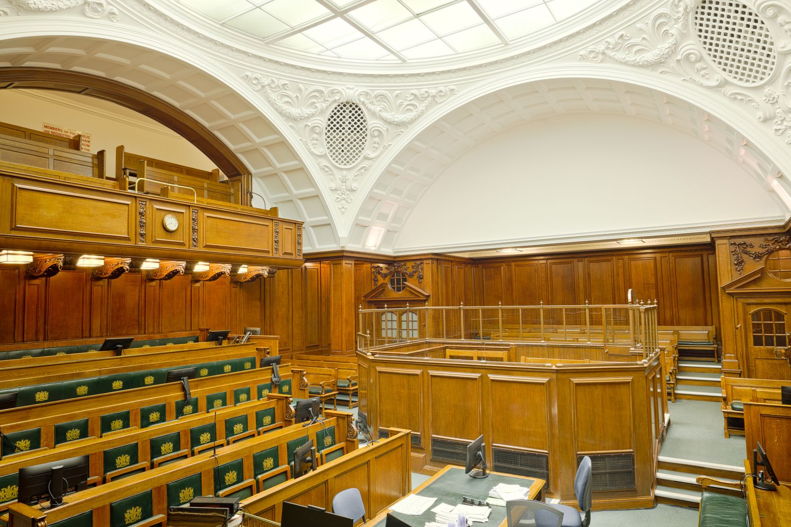 Wood-panelled chamber with rows of empty seats
