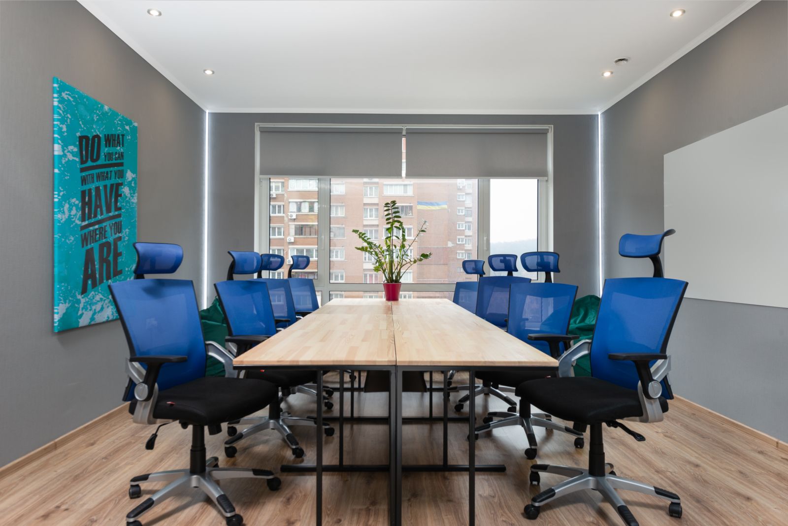 Meeting room with blue chairs around a wooden table