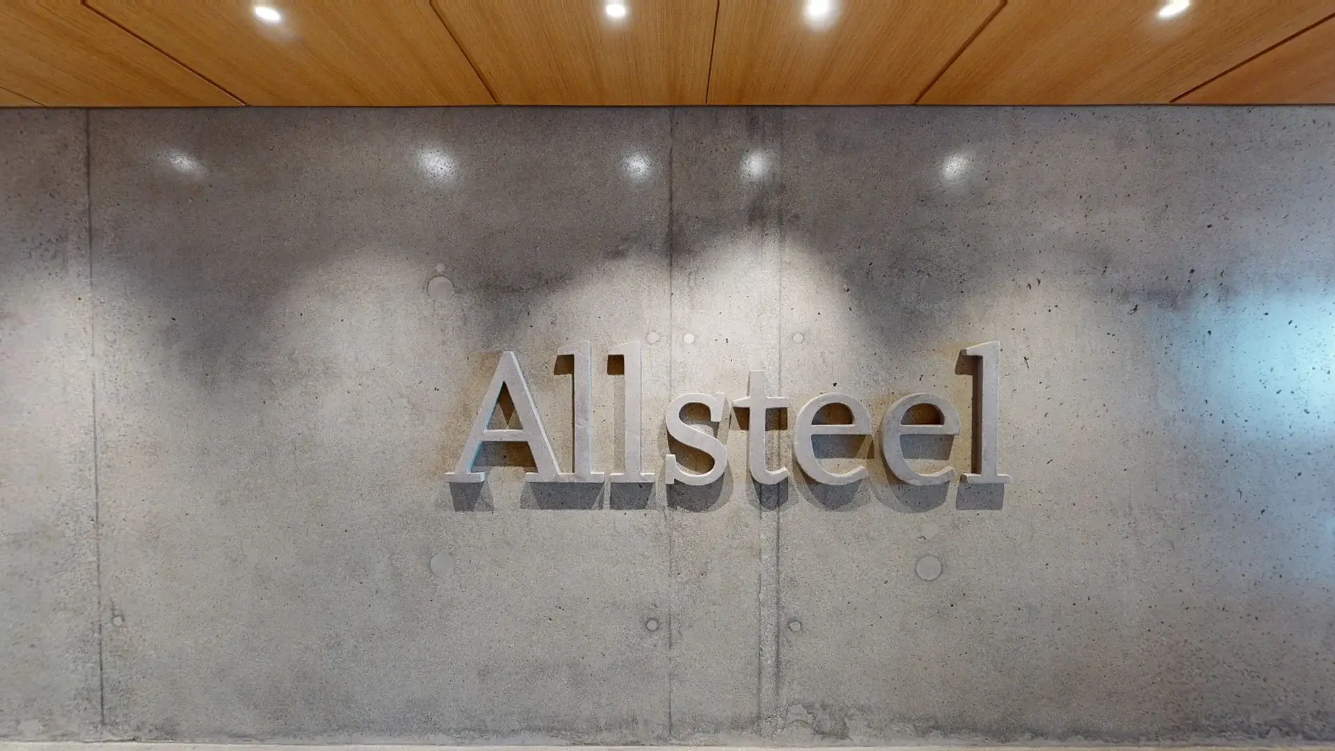 Modern Allsteel office entrance with concrete walls, wood ceiling, and polished floors.
