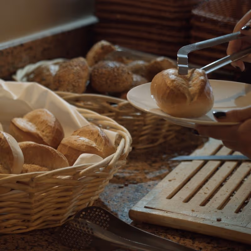 Frische Brötchen in Körben mit Zange, bereit zum Servieren