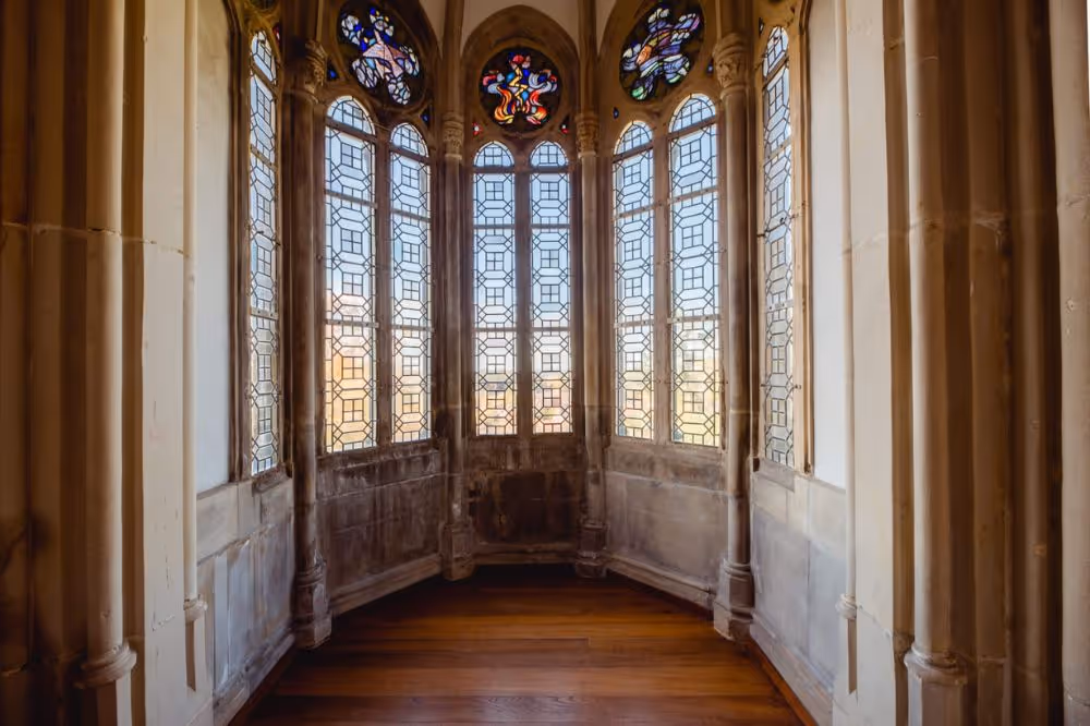 Gotische Kirchenfenster mit Buntglas und Holzboden in historischem Gebäude