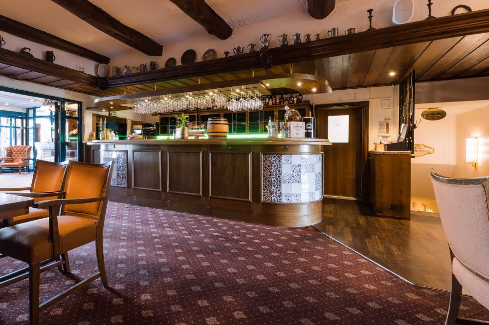 Gemütliche Hotelbar mit dunklem Holz, Kronleuchtern und elegantem Design