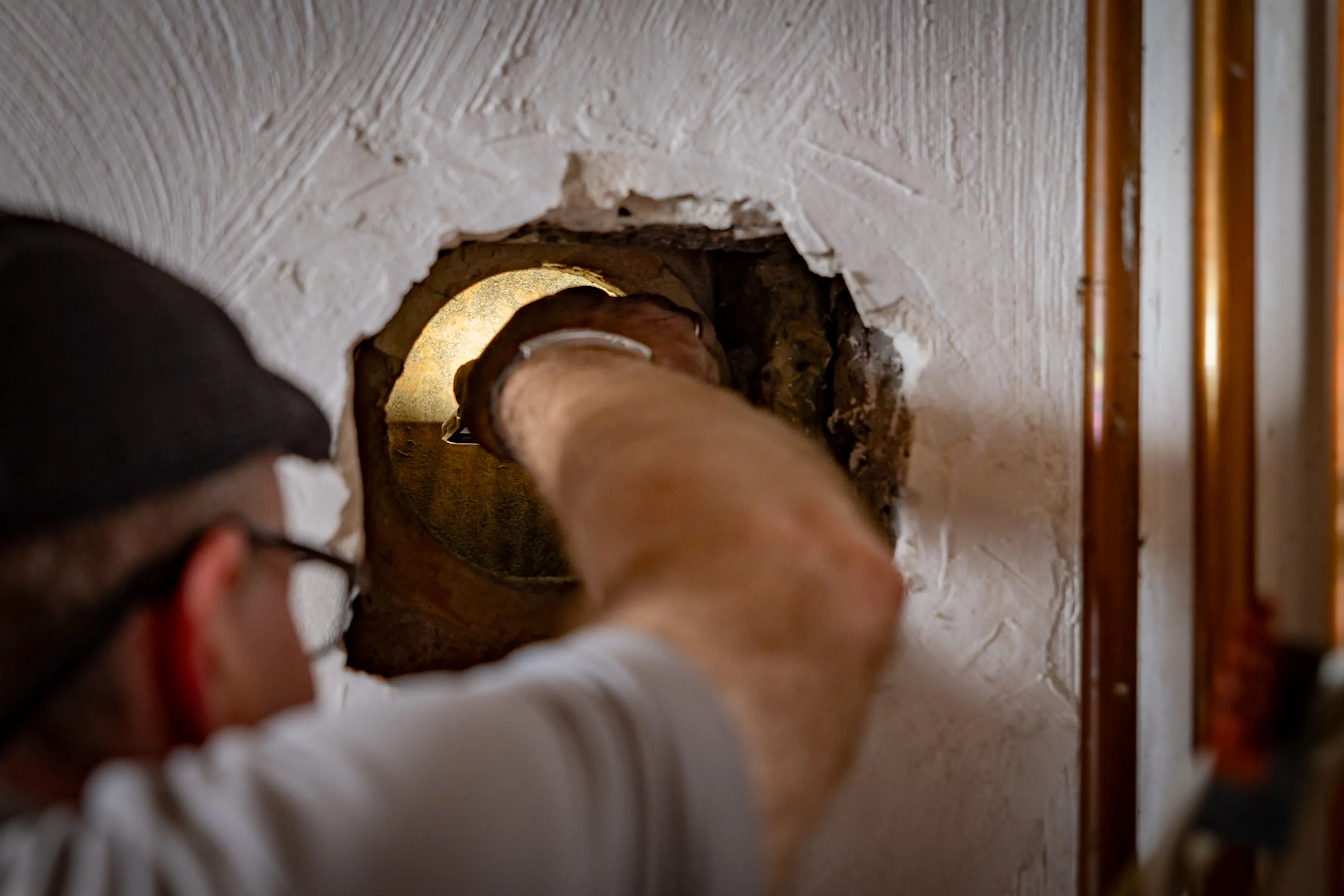 Mitarbeiter von André Viehöver untersucht Leitung in der Wand