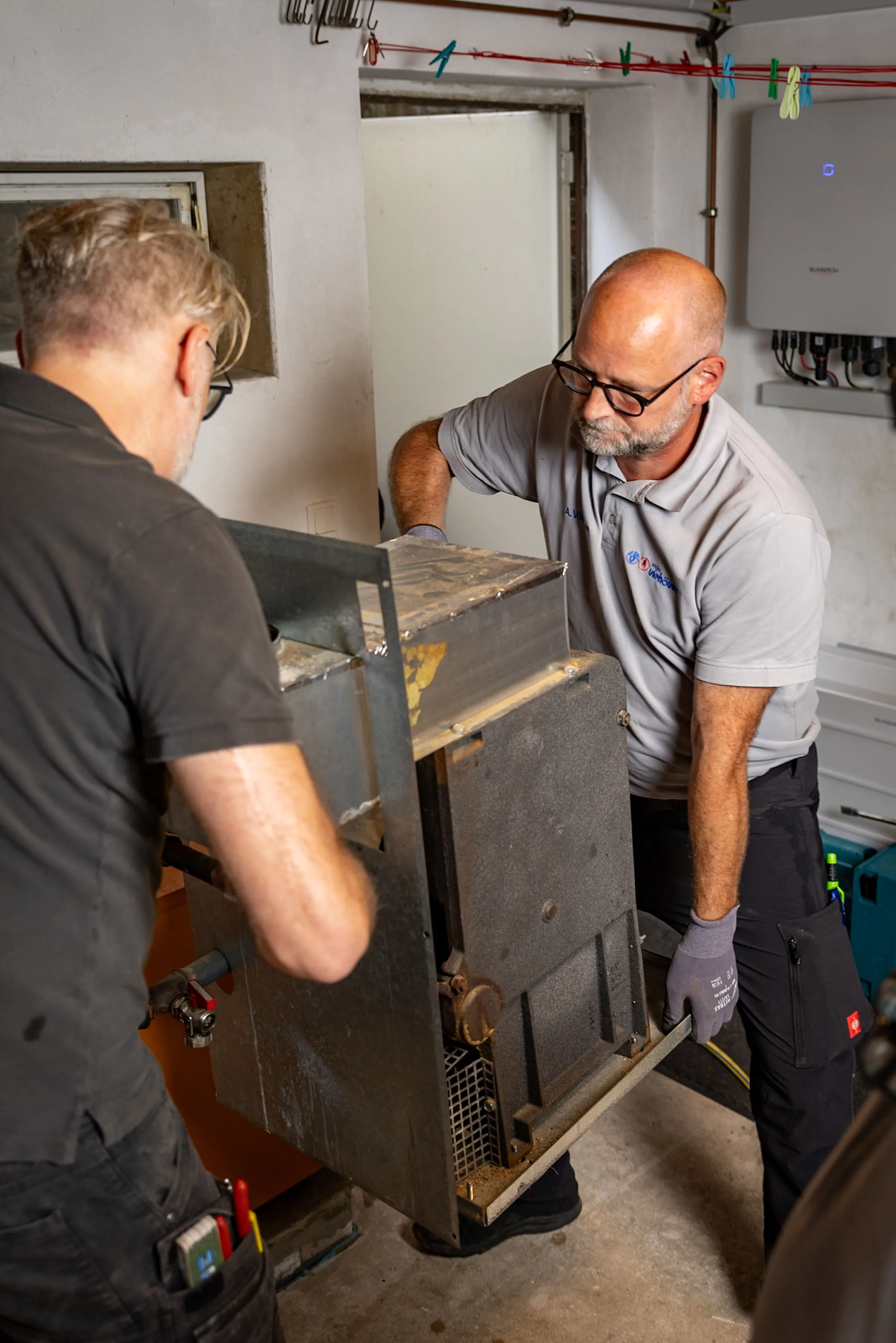 André Viehöver und Mitarbeiter transportieren Heizungsanlage