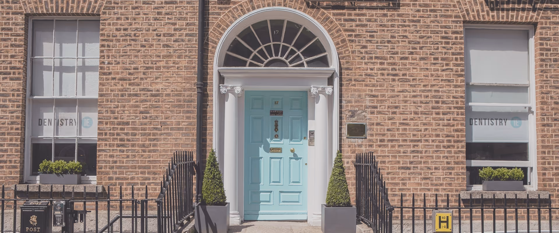 A blue front door of a brick building.