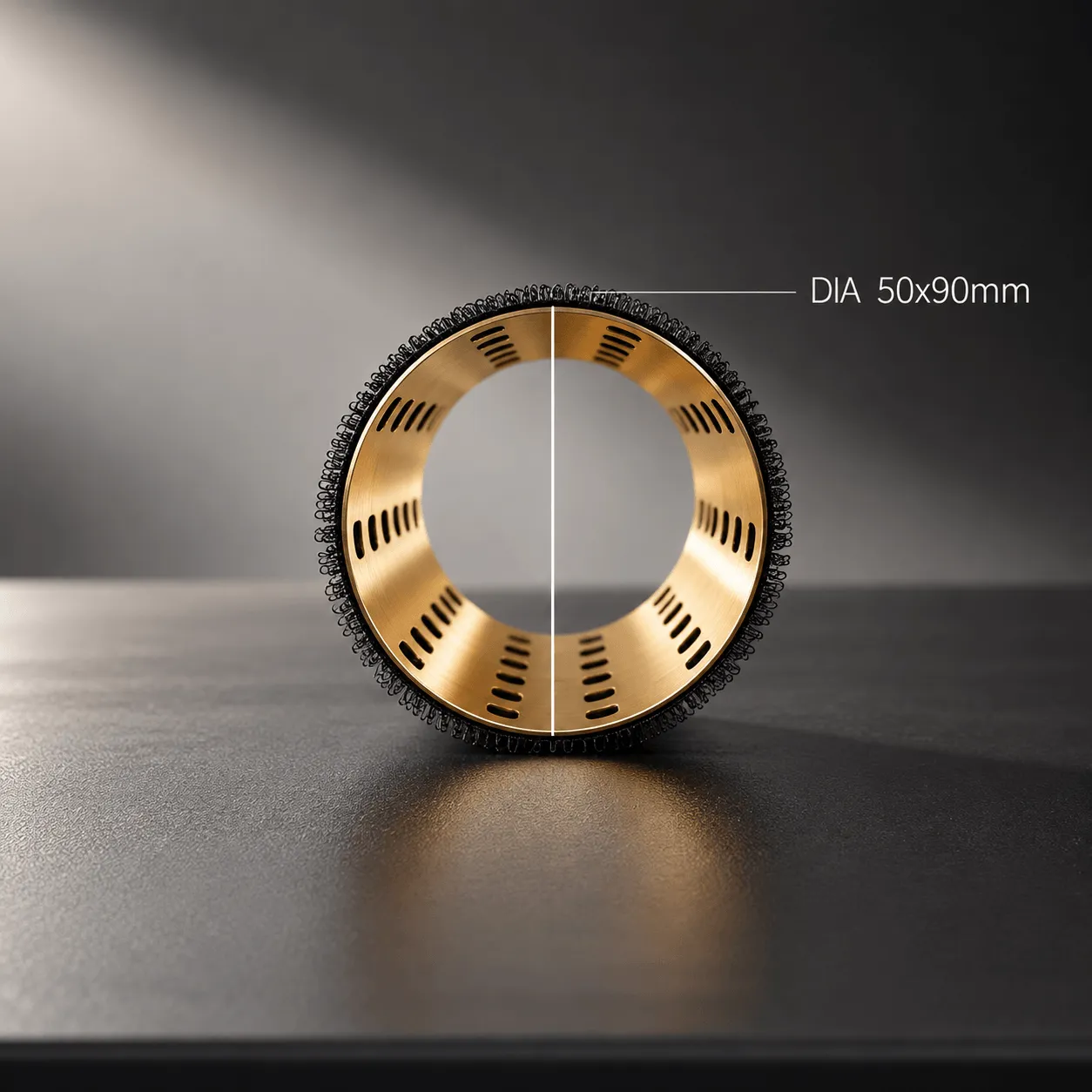 Close-up of a golden cylindrical mesh roller with black outer loops standing upright on a textured dark surface, with a measurement line indicating diameter of 50x90mm.