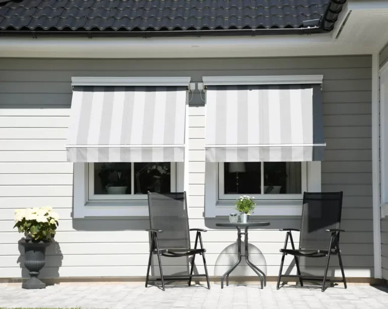 Randiga fönstermarkiser utfällda över uteplats i villa i Stockholm