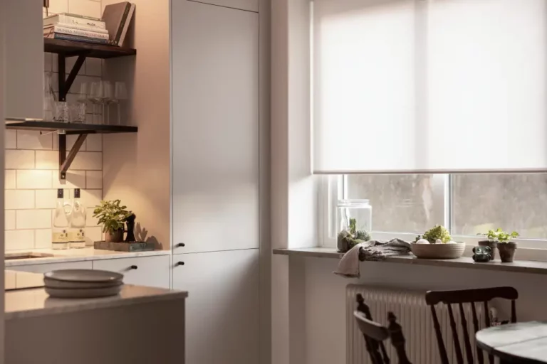 Halvt nedfälld vit semitransparent rullgardin i kök i Stockholm