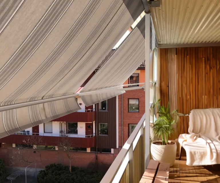 Randiga balkongmarkiser utfällda över balkong i Stockholm