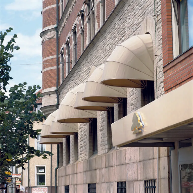 Beige utfällda korgmarkiser på fasad i Stockholm