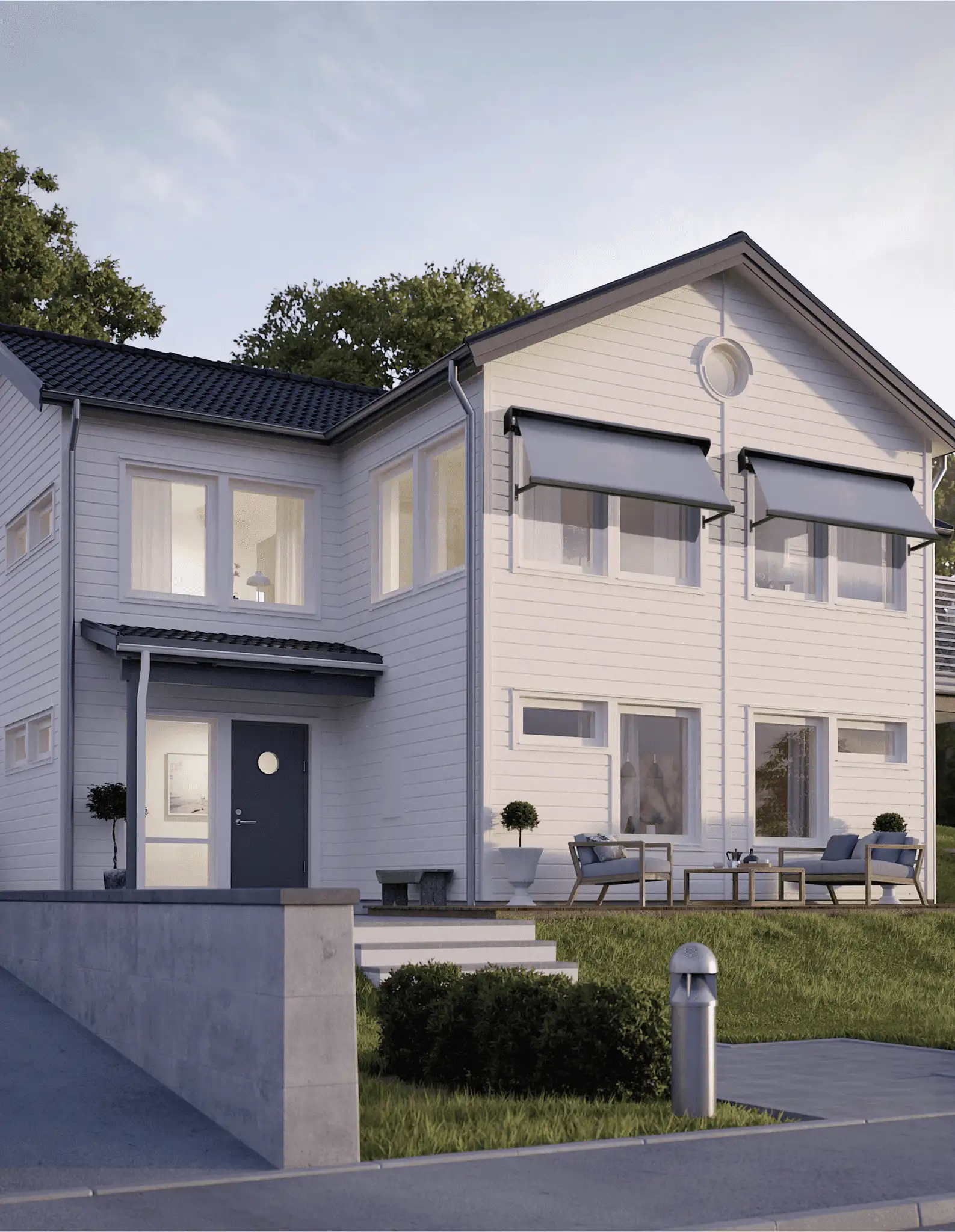 Modernt tvåvånings vitt hus med gråa fönstermarkiser, mörk entrédörr, stora fönster och uteplats med utemöbler i Stockholm.