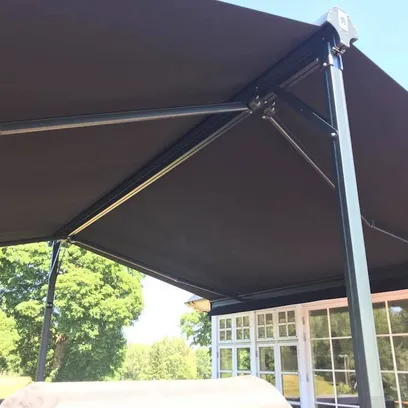 Svart terrassmarkis Duo monterad på en uteplats med glasskjutdörrar och gröna träd i bakgrunden i Stockholm.