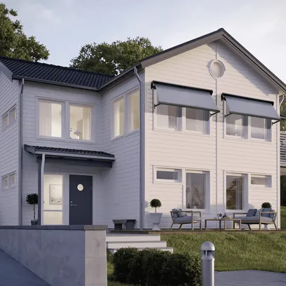Modernt tvåvånings vitt hus med gråa fönstermarkiser, mörk entrédörr, stora fönster och uteplats med utemöbler i Stockholm.