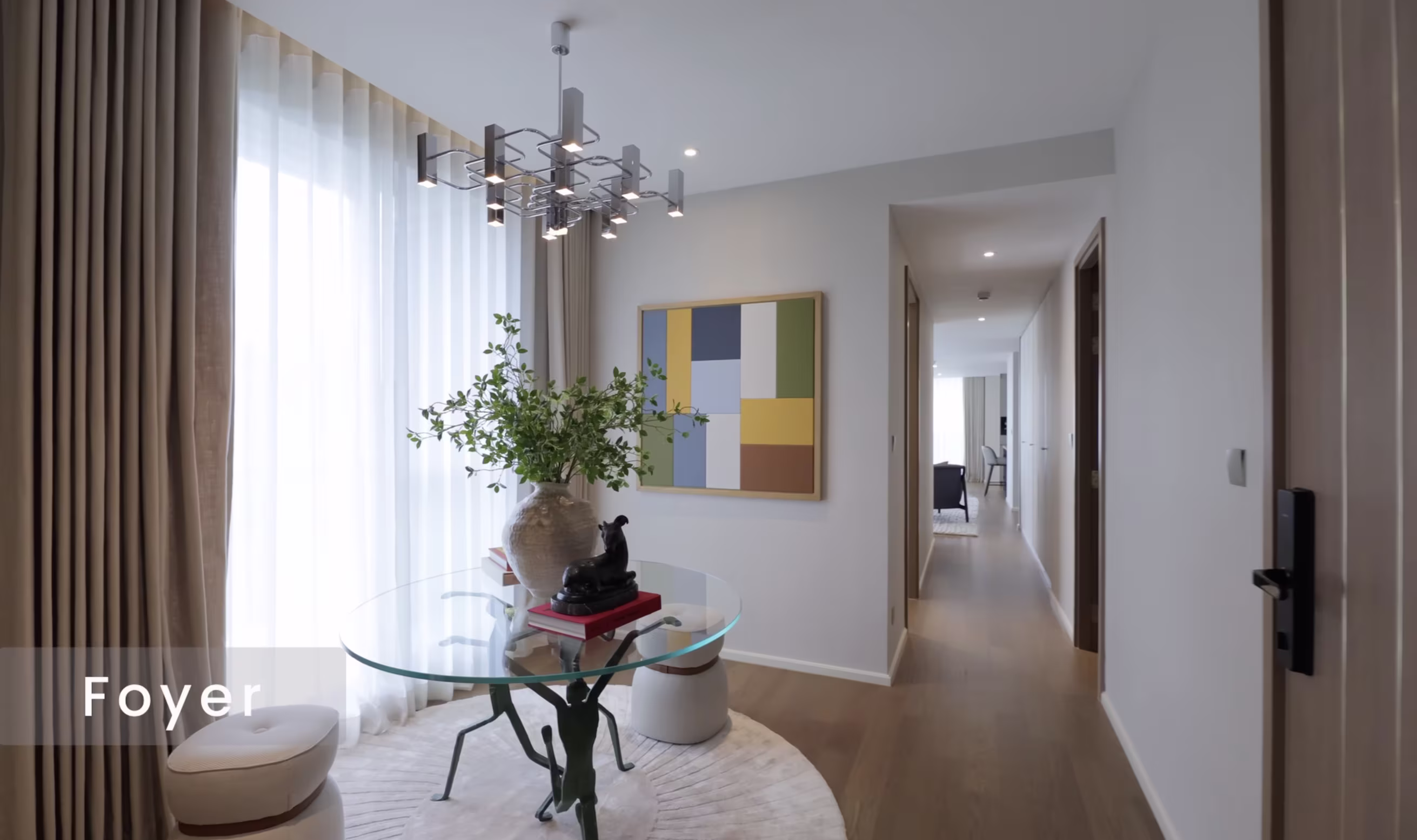 Via 34 three-bedroom unit foyer with glass table and artwork