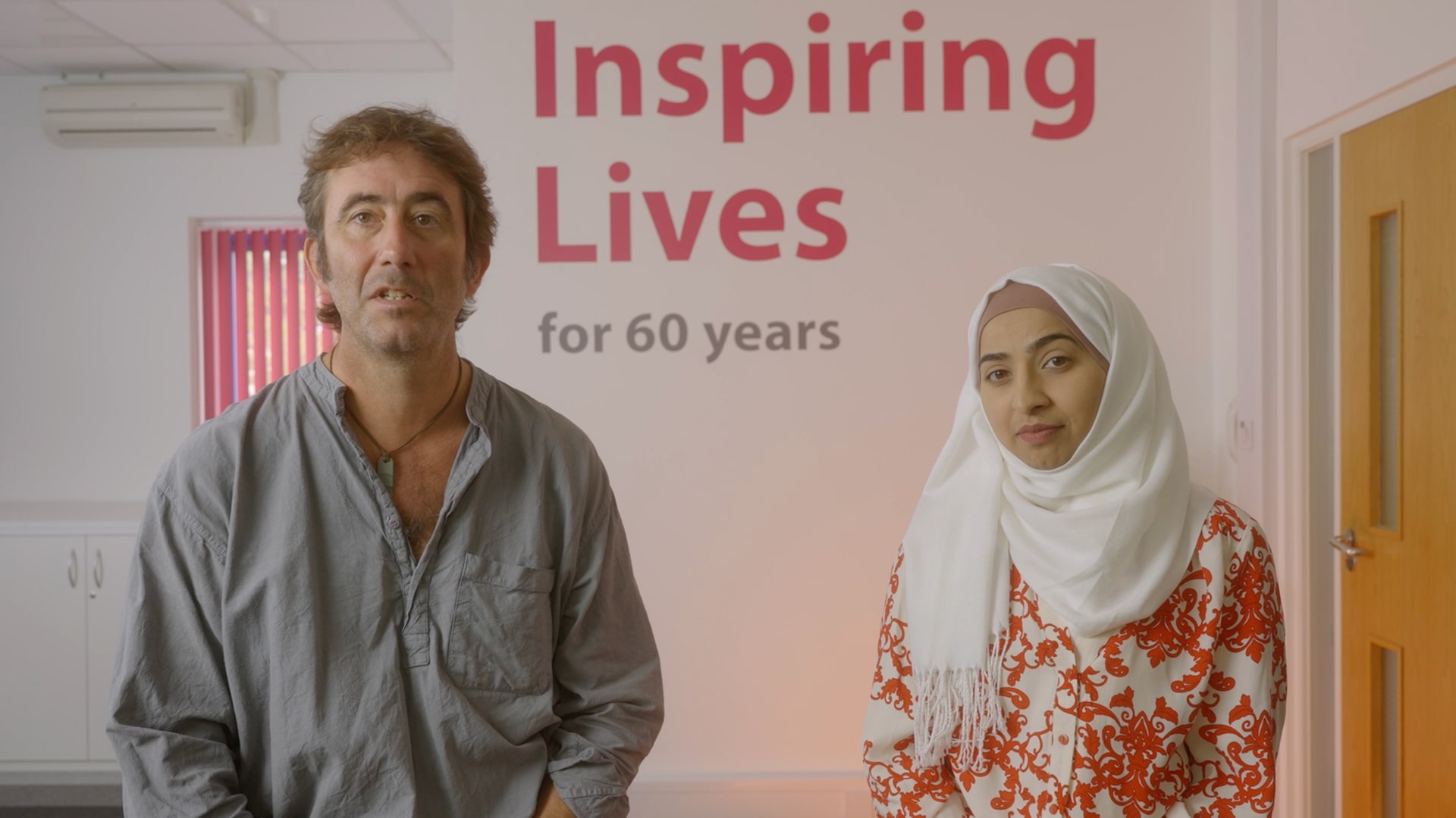 Celebrating 60 years of Inspiring Lives with a dedicated couple standing proudly.