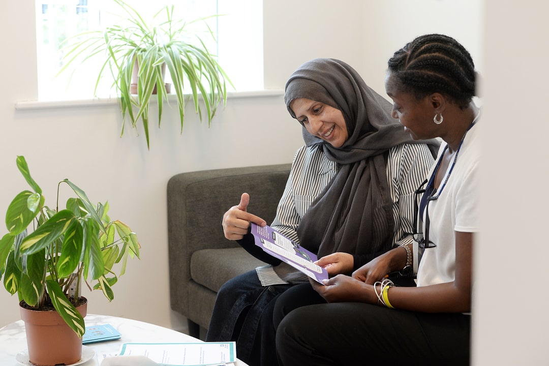 2 ladies talking whilst looking at leaflet