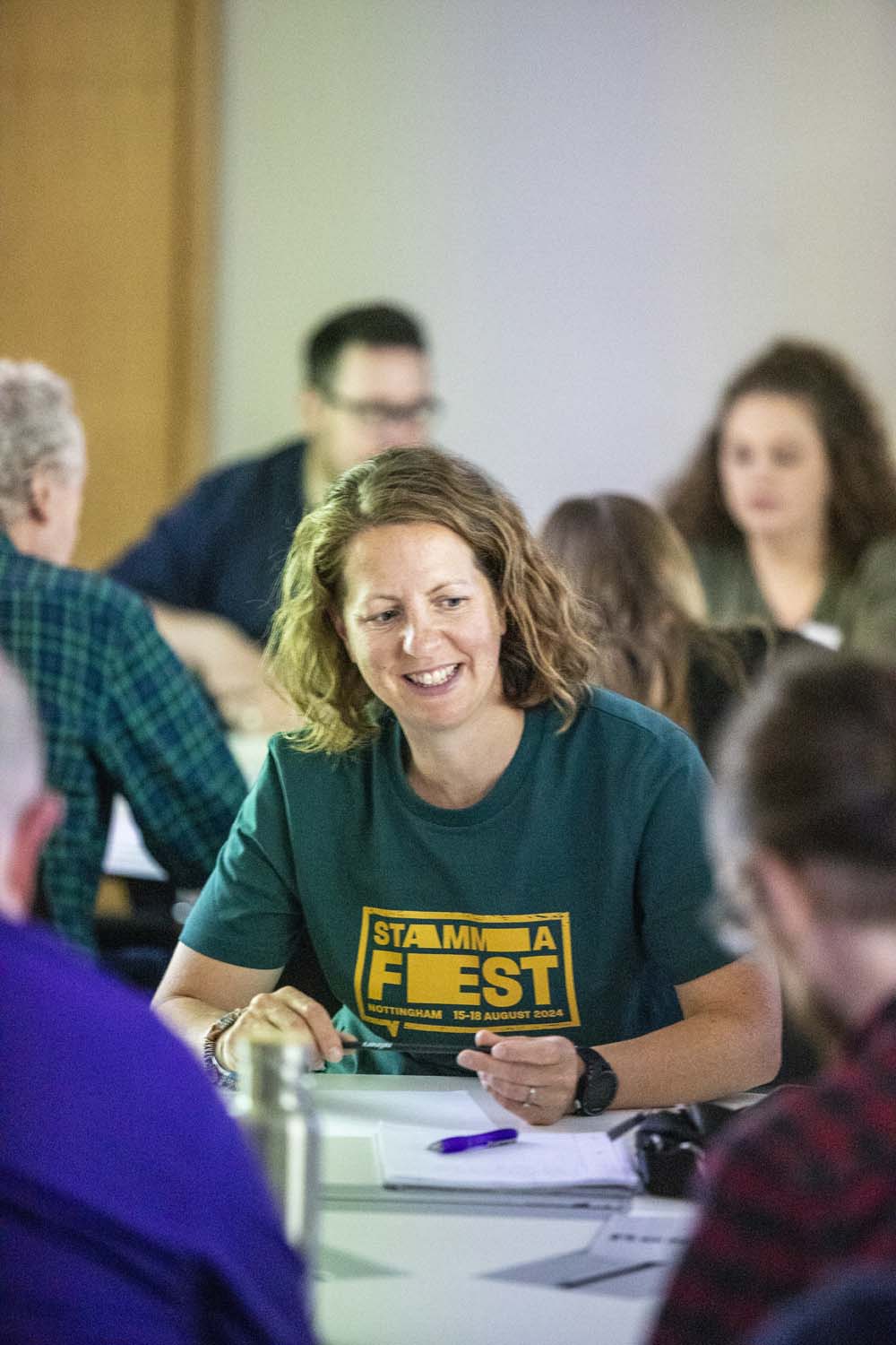 Woman in workshop discussion wearing STAMMAFest t-shirt