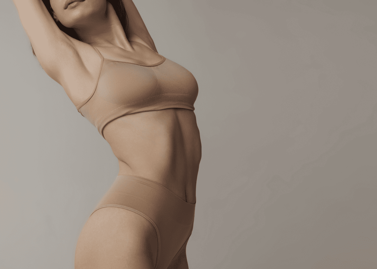 A woman in a tan bikini posing for a picture.