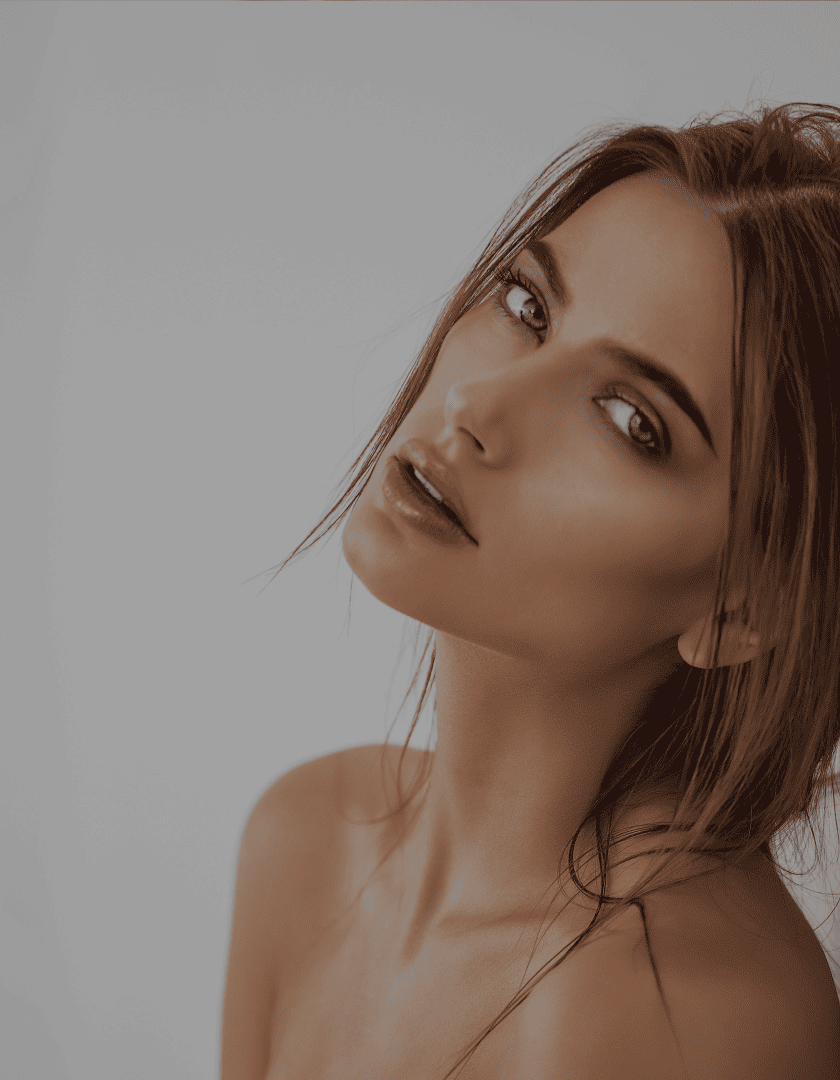 A woman is posing for a picture with her hair blowing in the wind.