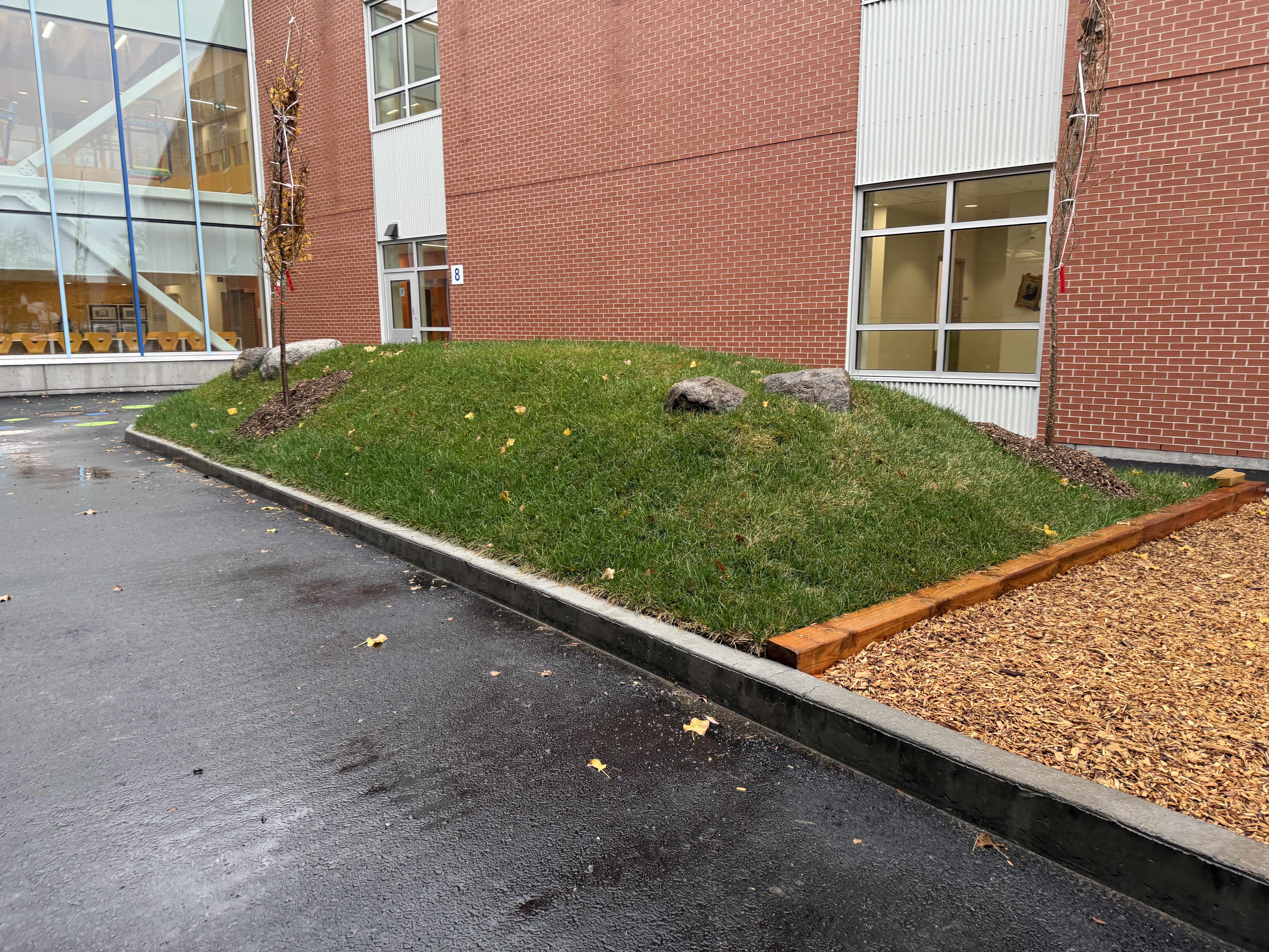 Dalles en béton gris foncé posées à gauche et dalles en béton gris clair empilées à droite séparées par une bordure en pierre claire.