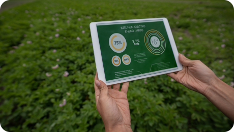 Person holding a tablet displaying agricultural data summary against a green field background.