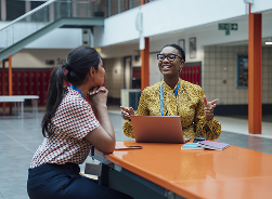 Image of two students chatting in class