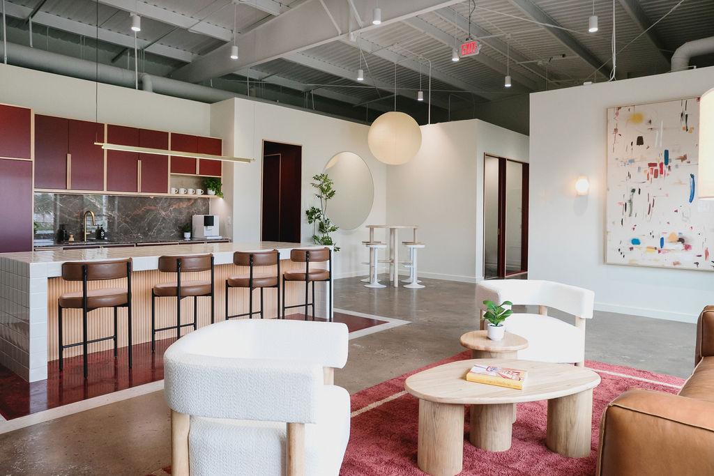 Common area at Junto House showing the kitchen, standing table, and lounge in one frame.