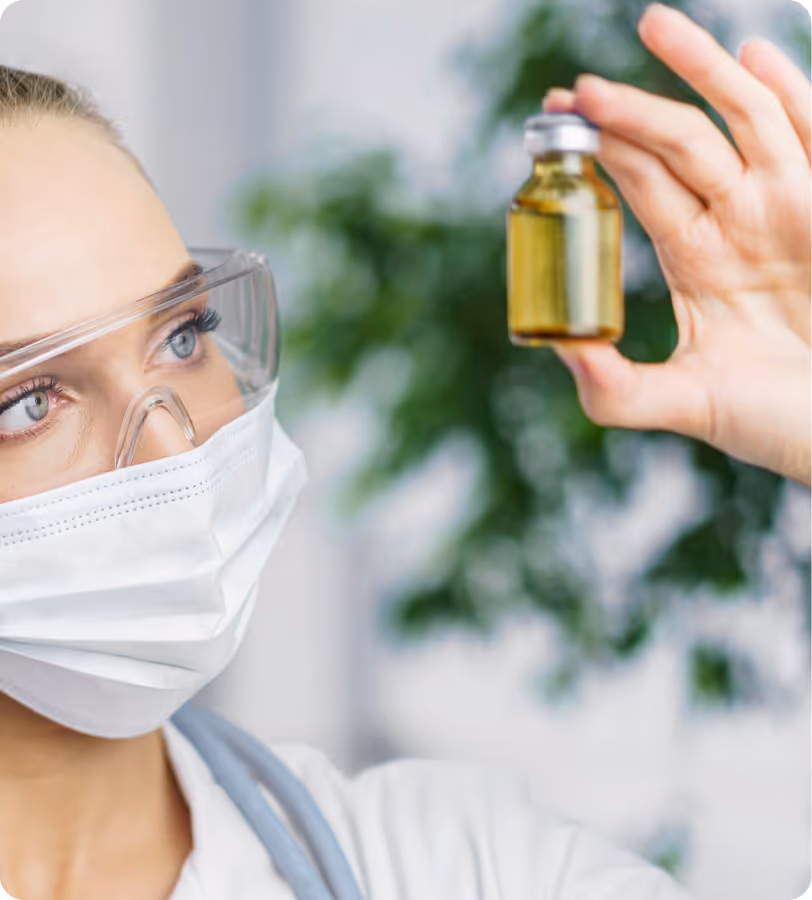 Doctor holding glass bottle of medical oil in her hand