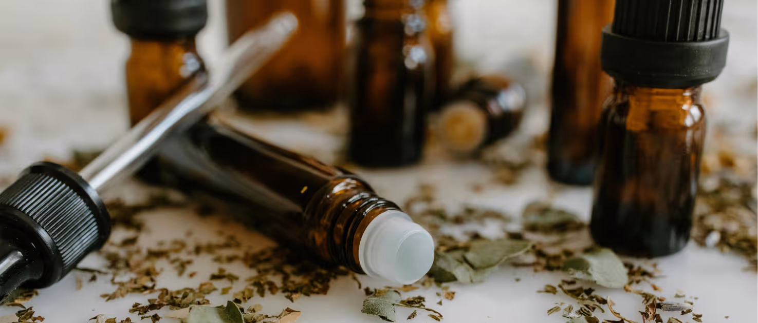 Bottles of medical oil with herbs on the table