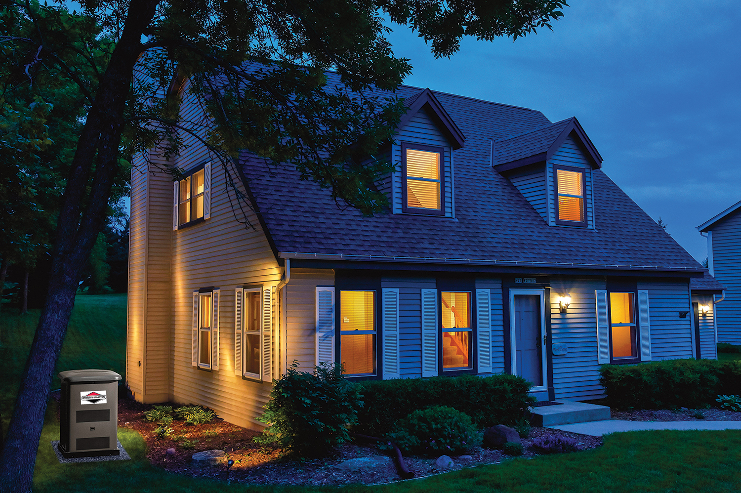 A house at night time with lights on and a generator