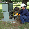 A person working on an electrical box outside