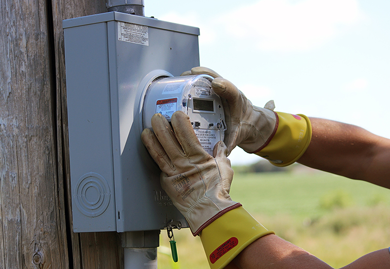 A person working on an electrical meter with safety gloves
