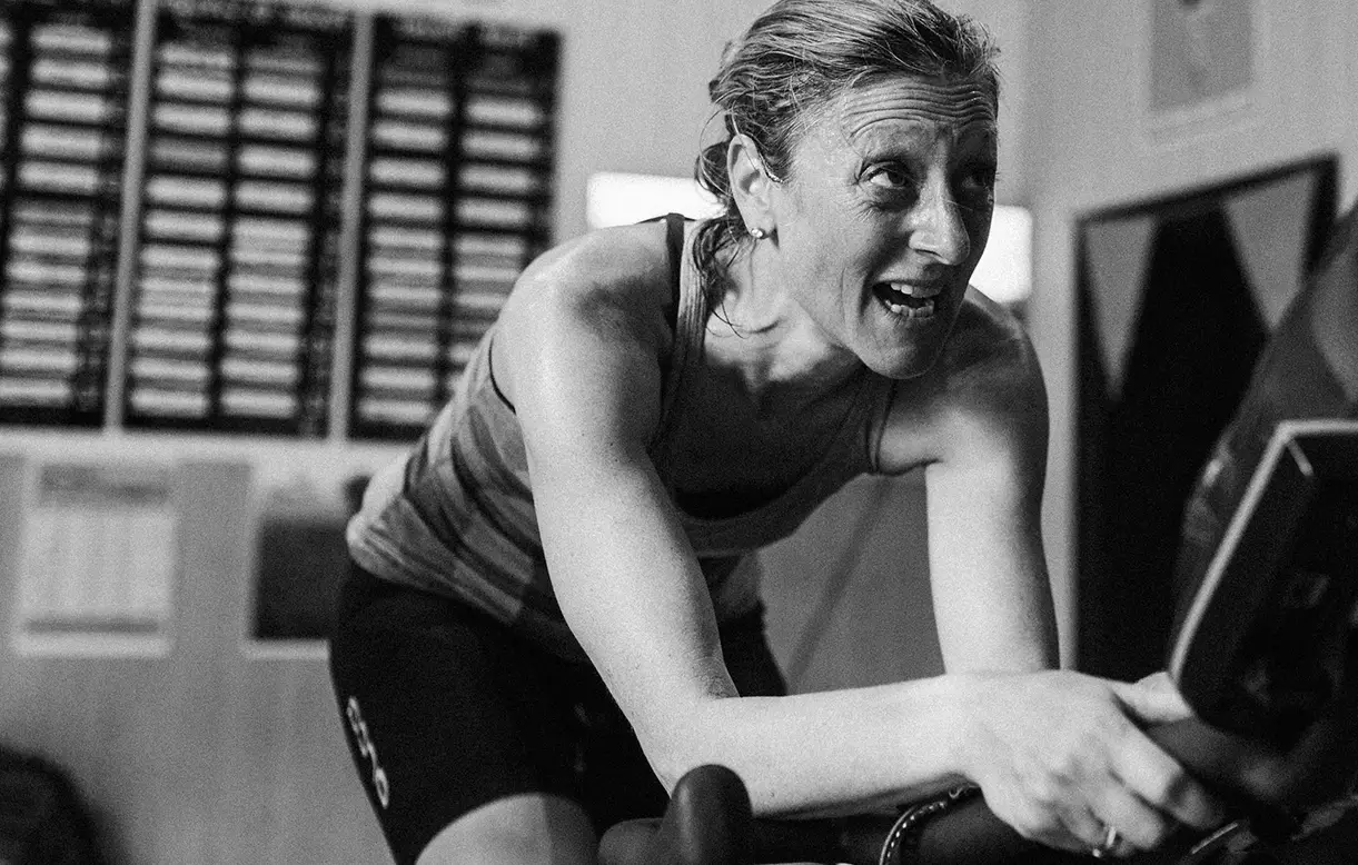 Indoor cyclist pushing on a smart trainer during a coach-led session, Accelerate experience