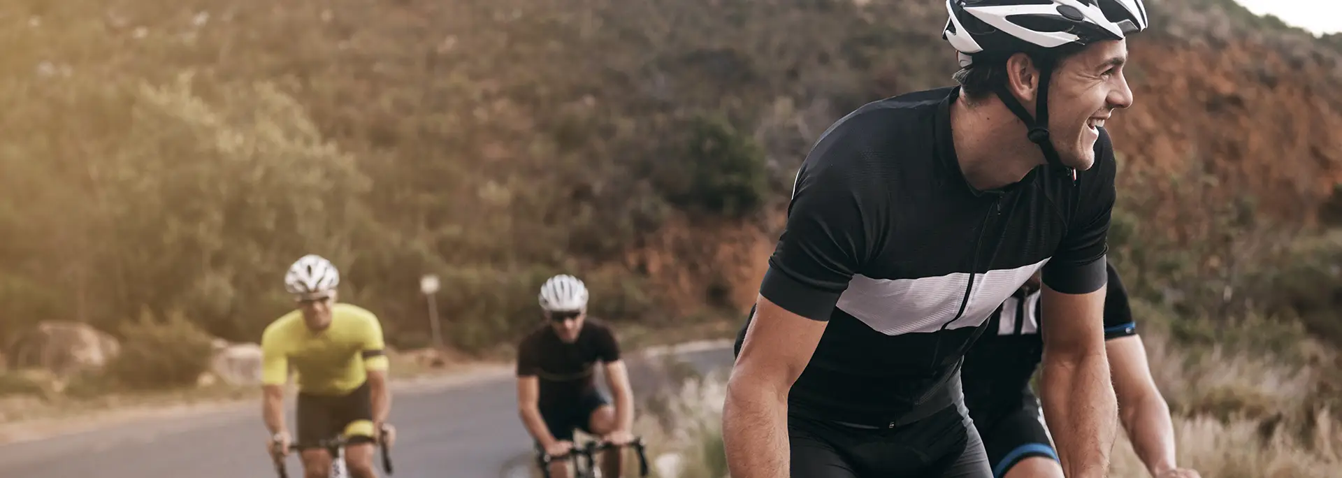 Road cyclists climbing together at golden hour – book a free 15 minute coach call