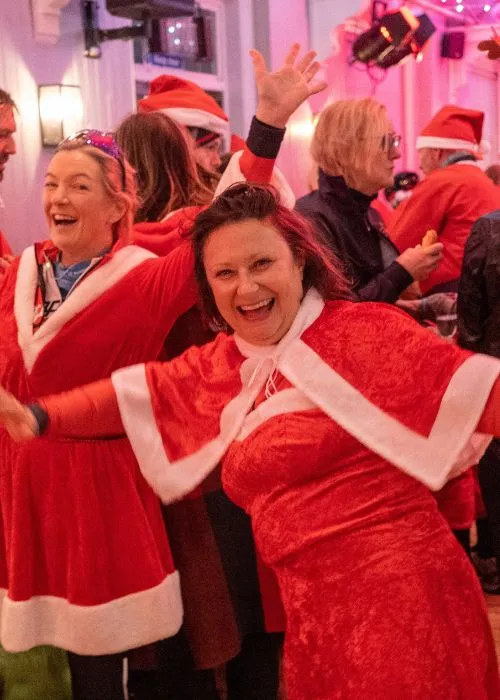 Two Santas celebrating at the post-ride fundraiser party