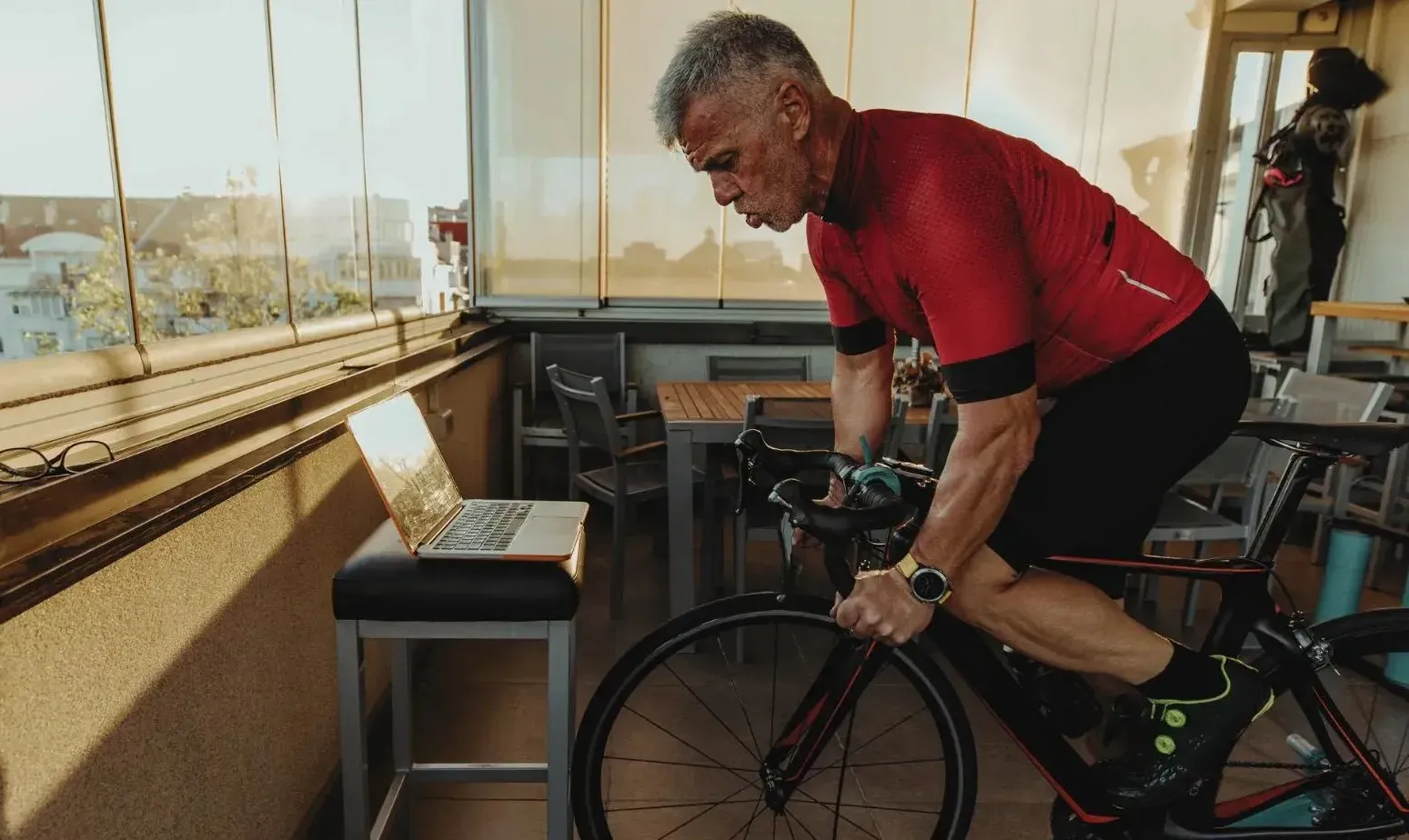 Three cyclists smiling and riding together on a mountain road — group cycling coaching for accountability and results