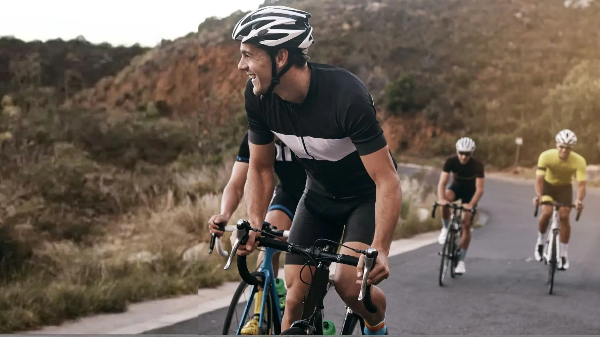 Three cyclists smiling and riding together on a mountain road — group cycling coaching for accountability and results