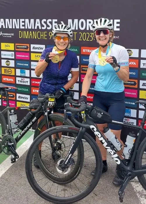 Two cyclists in their 40s smiling after completing challenge ride successfully due to proper age adapted training