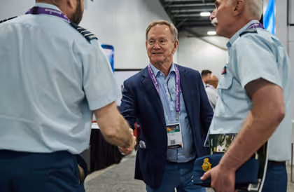 Les participants font du réseautage et se serrent la main sur le plancher de l'exposition CANSEC.