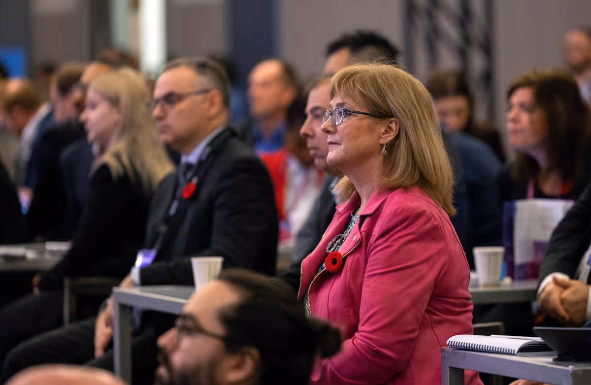 Delegates networking and exchanging ideas in a crowded conference hall at Cyber and Digital Outlooks.