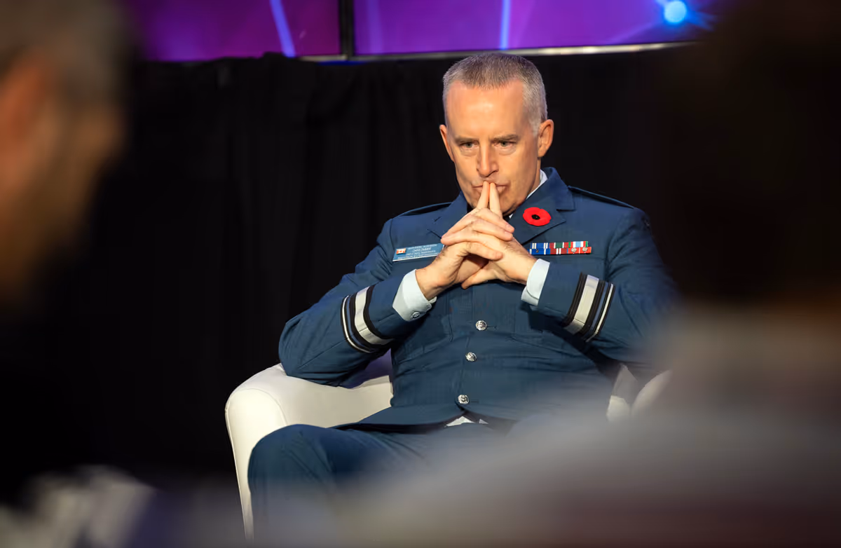 Officier militaire prenant la parole sur une tribune lors d'une séance axée sur l'innovation numérique et la cybersécurité.