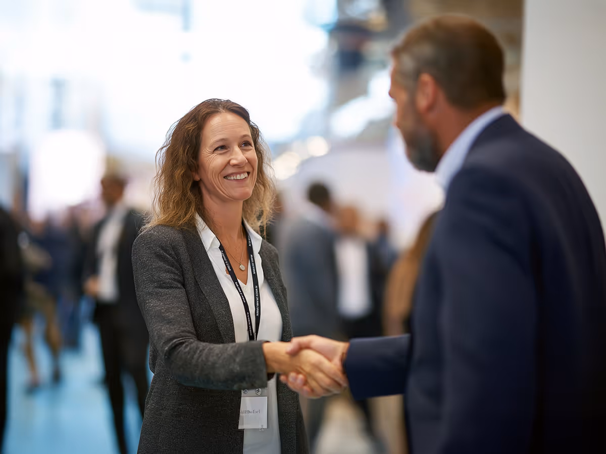 Two professionals greeting each other at a business event, representing CADSI membership opportunities and networking.