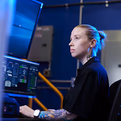 Engineer operating advanced defence technology equipment in a modern control room.